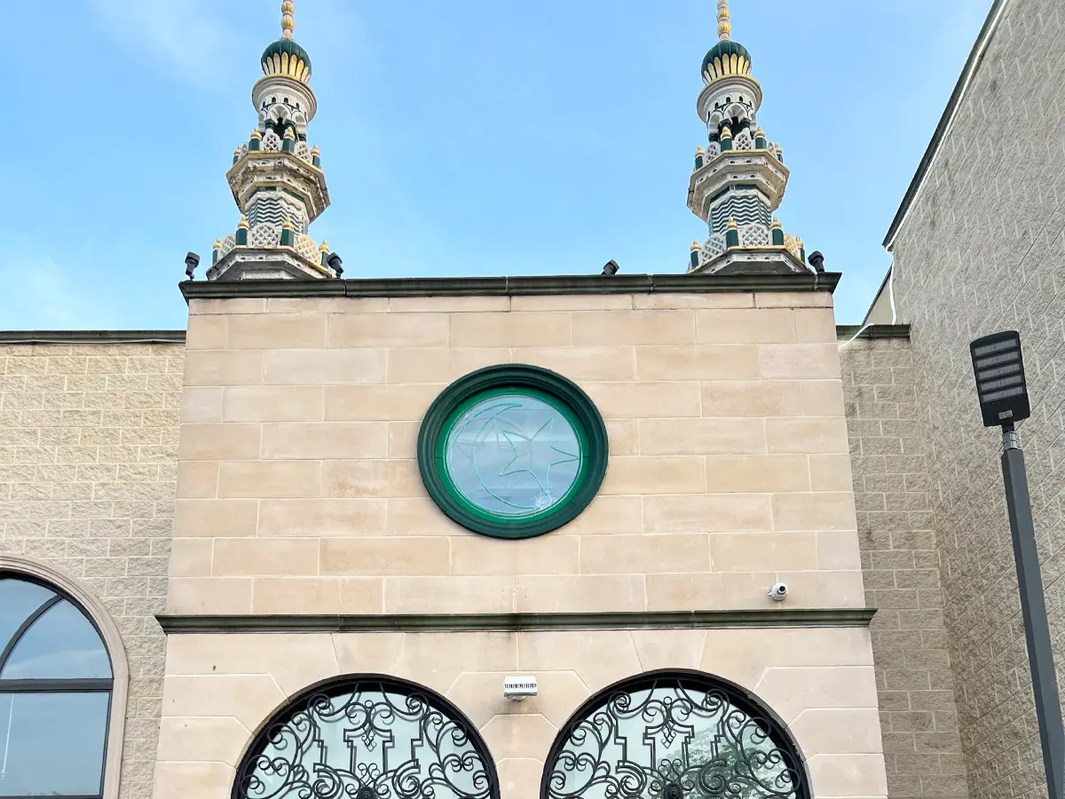 Close-up of mosque minaret architecture and decorative green-stained glass in Al-Wali Center.