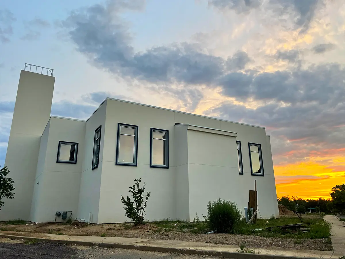 Minimalist white mosque exterior at sunset - Showcasing a mosque's clean architecture against a dramatic sunset.