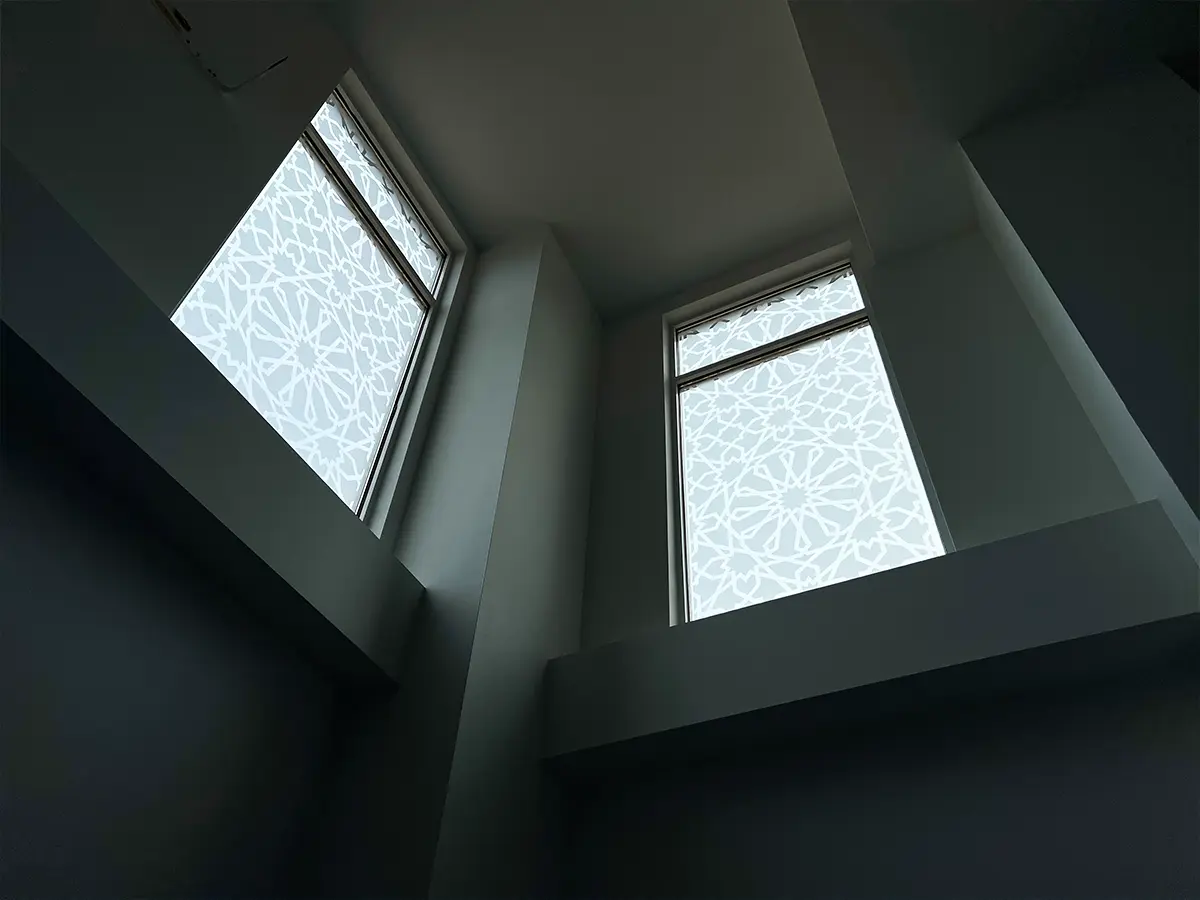 Sunlit windows with Islamic geometric frosted patterns - Displaying detailed window designs that enhance natural light and privacy.