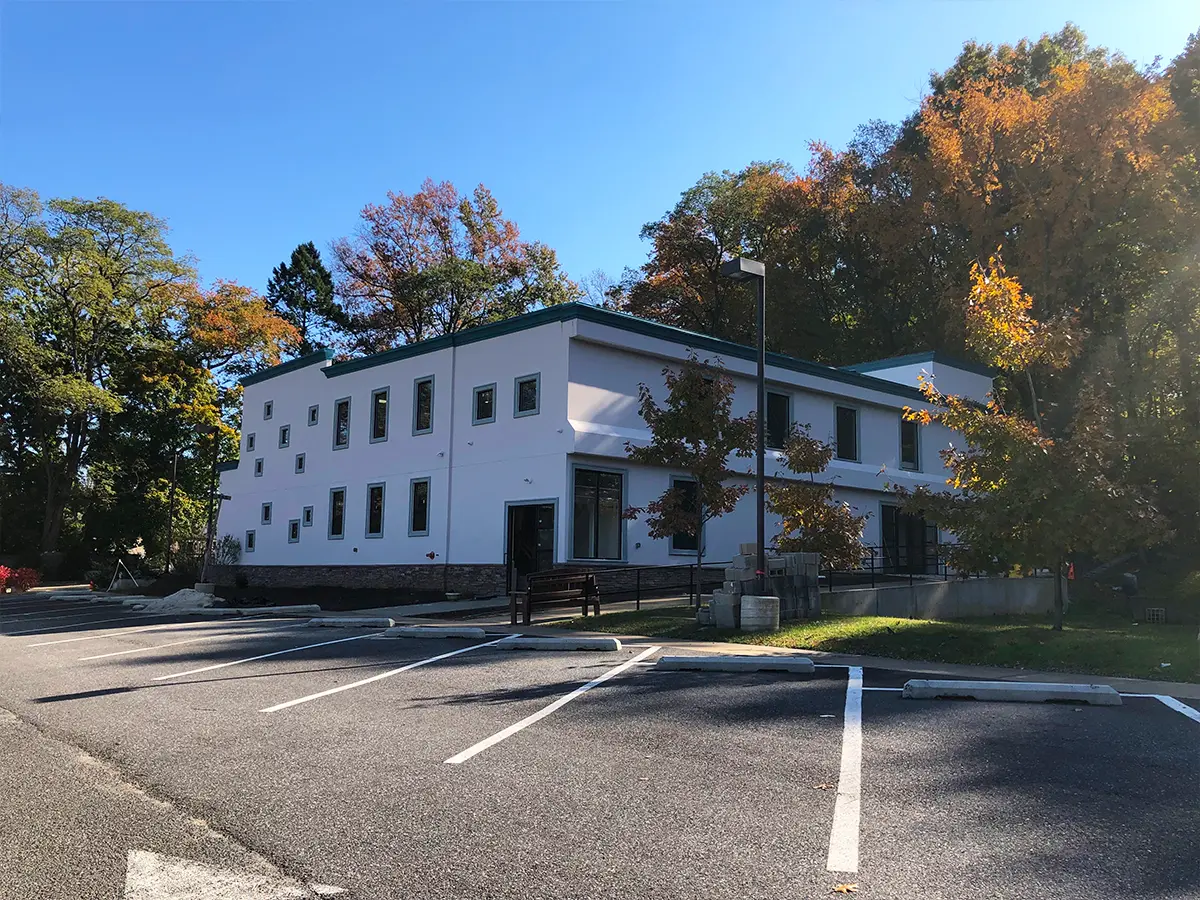 Exterior view of a mosque surrounded by autumn trees, featuring clean architectural lines and accessible parking.